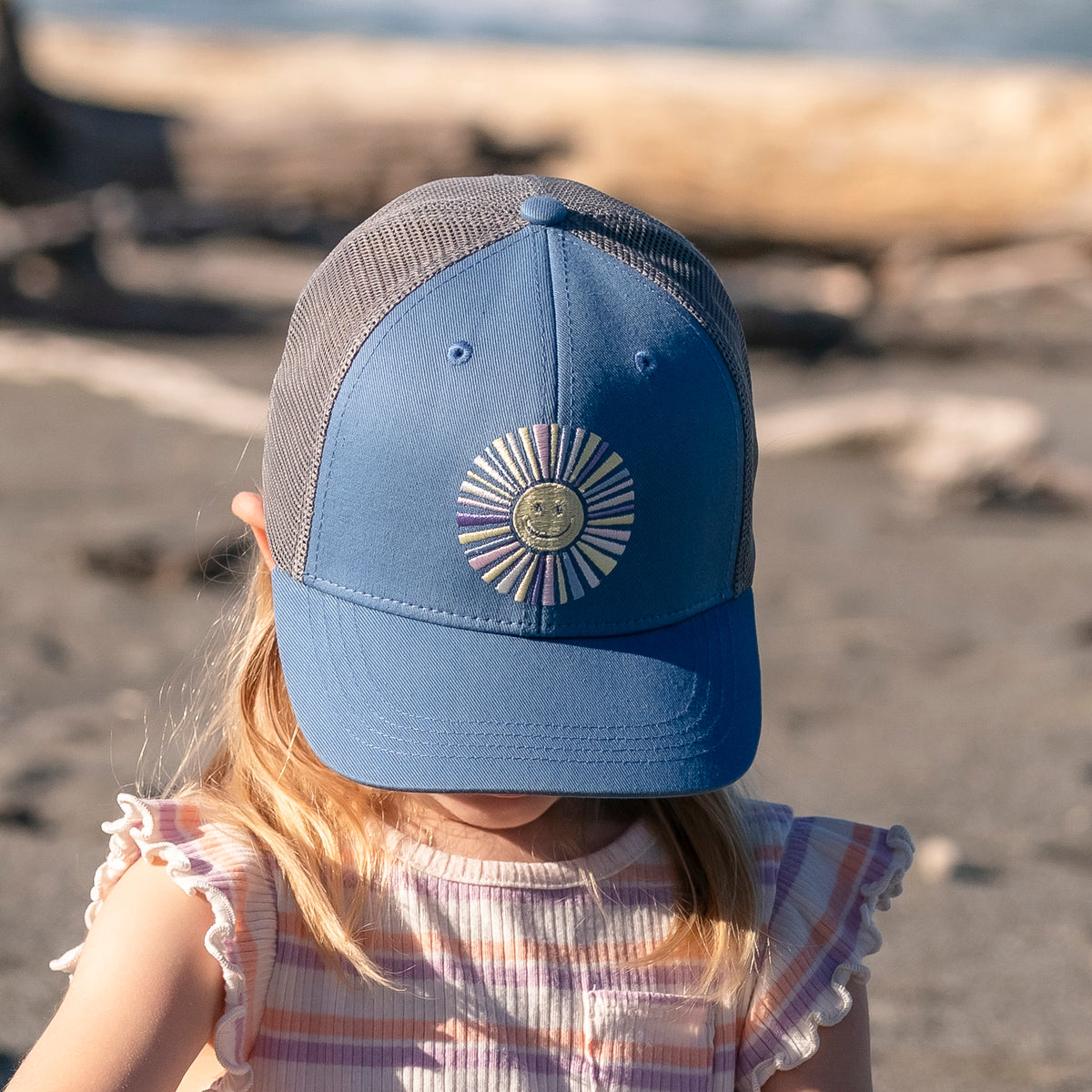 Child wearing a Sunday Afternoons Kids' Feel Good Trucker in the Happy Sun color.